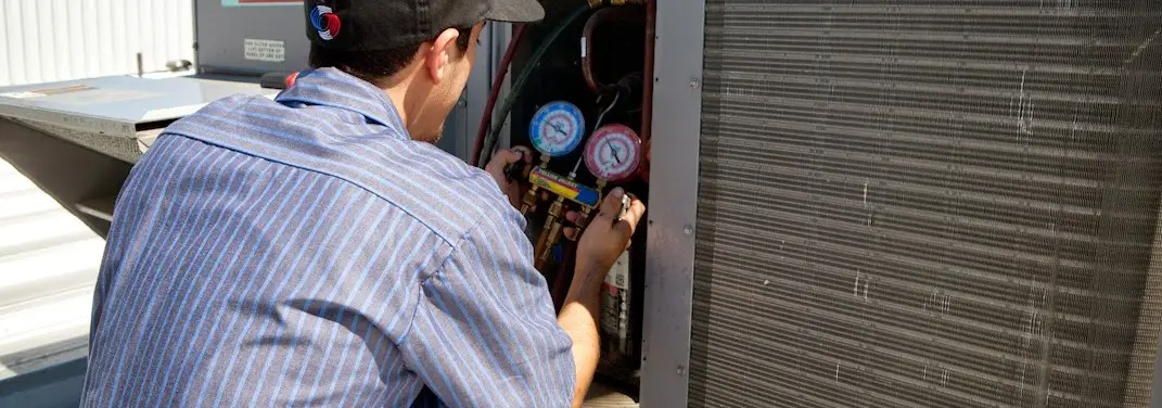 HVAC technician servicing a condenser unit in Halifax
